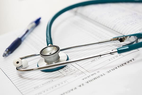 A photo of a stethoscope, pen and chart.